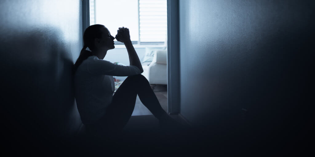 Desperate woman saying a prayer. Young woman at home feeling desperate saying a prayer.