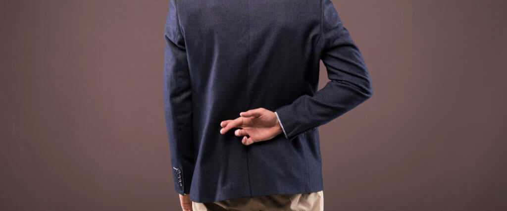 Man in a suit crossed his fingers behind his back Businessman fingers crossed behind his back