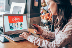 Young woman shopping online Young woman sitting in a cafe and holding credit card