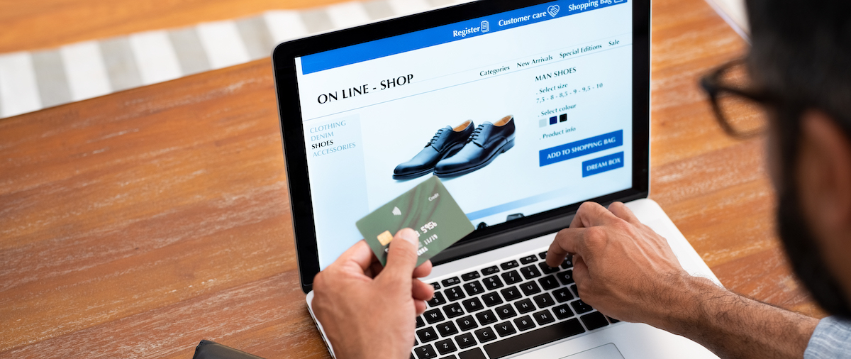 Man doing shopping online Man using credit card to do shopping online with laptop. Mature man buying formal shoes online. Man making online payment with credit card and laptop.